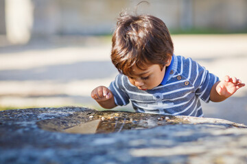 Portrait of a little eastern handsome baby boy playing outdoor in the park