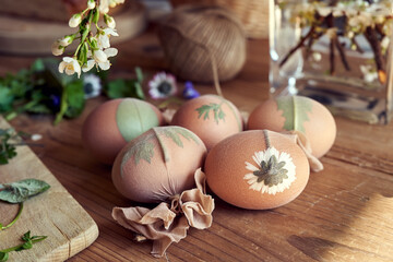 Easter eggs with plants attached to them with old nylons - preparation for dyeing with onion peels