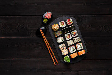 japanese set, roll philadelphia classic, salmon teriyaki, spicy salmon, yasai maki, on a black plate, top view, horizontal, no people, 