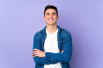 Fotobehang Teenager caucasian  handsome man isolated on purple background keeping the arms crossed in frontal position © luismolinero