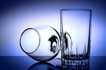 cognac glass and whiskey glass on blue gradient background