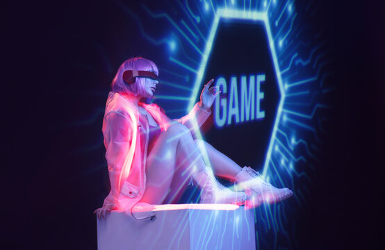Beautiful woman with purple hair in futuristic costume on dark background. Girl in glasses of virtual reality. Augmented reality game, future technology, AI concept. Holographic interface.