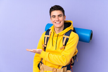 Teenager caucasian mountaineer man with a big backpack isolated on purple background extending hands to the side for inviting to come