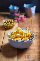 vol of potato chips in the foreground on a rustic background