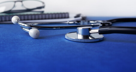 Medical stethoscope and clipboard with a blank sheet of paper. Medical concept. Selective focus.