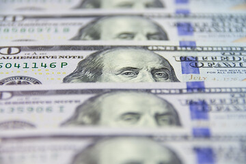 Close-up of one hundred US dollar bills with portrait of president Benjamin Franklin as business conceptual background