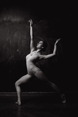 Modern style dancer posing on a studio dark background