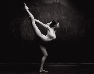 Young beautiful dancer posing in studio. girl with a good stretch