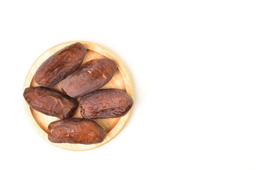 Top view of Dates on a wooden plate isolated on a white background with copy space