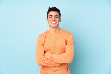 Teenager caucasian handsome man isolated on purple background laughing