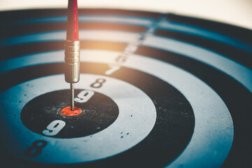 Close up shot of the dart arrow hit on bulleyes of dartboard to represent that the business reached...