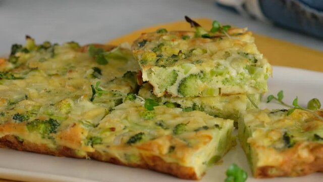 Close-up. Broccoli frittata sprinkled with microgreens on a plate. Italian breakfast. Baked chopped omelet with vegetables and broccoli on a serving plate. Healthy breakfast. Top view.