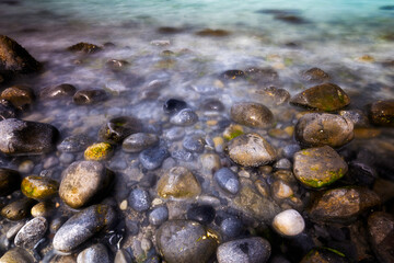 Fototapeta premium wet stones in sea water along the shore