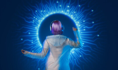 Beautiful woman with purple hair in futuristic costume. Blue and violet neon light. Young girl in modern headphones listening music. Futuristic holographic interface.