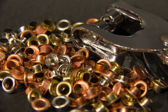 Lot of Grommets eyelet brass bronze copper close up macro isolated dark