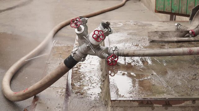 Fire hose with water at the site of a fire in a building in the city. Close-up. Fire extinguishing with water from a hydrant