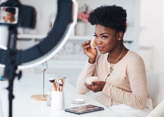 happy young african american woman streaming a beauty vlog from home, online content creator...