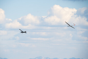 Plane pulling a glider, blue sky clouds