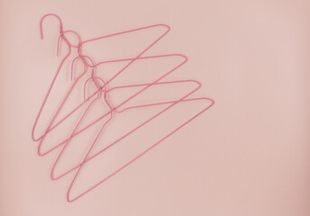 Metal pink hangers for clothes on pink background.  Empty cloth hanger template. Fashion blog,  sales,  store, online  shopping concept. 