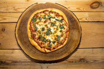 A delicious home made cheese Pizza on a wooden kitchen table