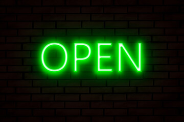 Green neon sign OPEN on a brick wall.