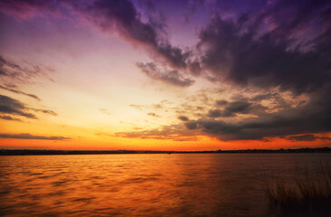 Naklejka na ściany i meble colorful sunset at the river bank