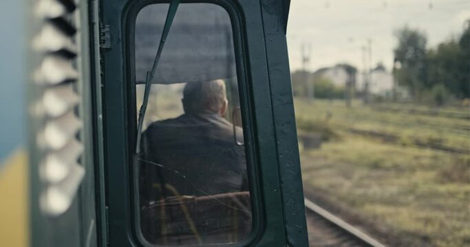 Cinematic shot of moving locomotive and conductor. Shaking from motion. 4k