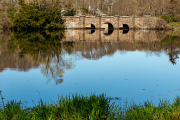 Bridge over a pond with reflection in spring