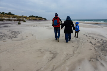 Poland, Hel Peninsula family walking on the beach in winter, during sunset time.