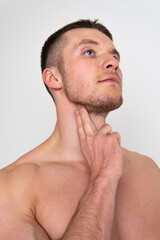 Obraz premium Checks the pulse of a man on his neck in a white background ache hurt painful, ill person caucasian massage muscular holding. Tension lumbar therapy, disease suffer attractive