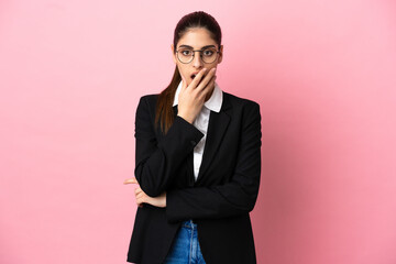 Young caucasian business woman isolated on pink background surprised and shocked while looking right