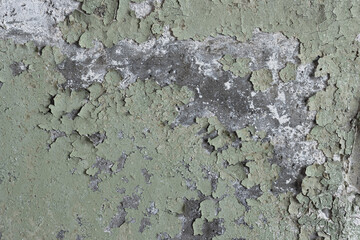 Peeling paint on the wall. Old concrete wall with cracked flaking paint. Weathered rough painted surface with patterns of cracks and peeling. High resolution texture for background and design. Closeup
