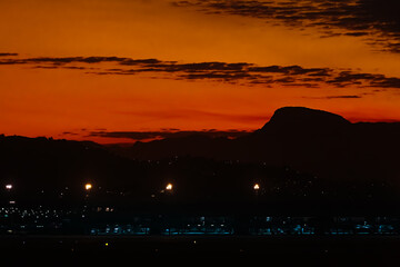Beautiful sunset in Vitória, seen from Vitória airport with night lighting in the foreground.