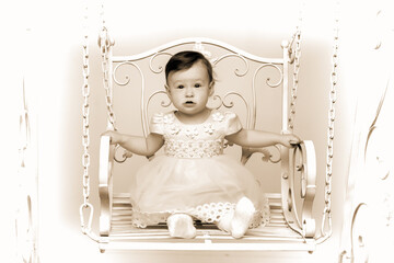 Happy little girl schoolgirl swinging on a swing.