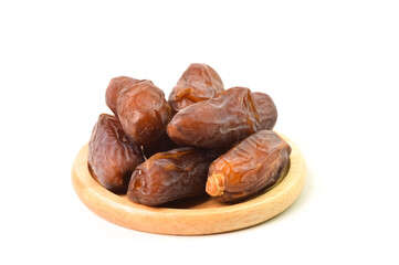 Front view of dried dates or kurma on wooden plate isolated on a white background