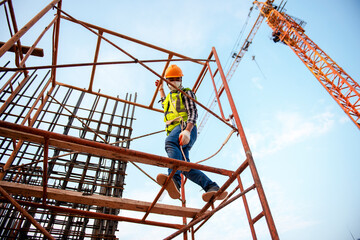 Construction workers wear safety harnesses and harnesses to work at heights during disease (COVID-19).