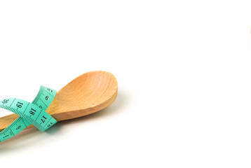 Measuring tape and wooden spoon isolated on a white background. Health concept.