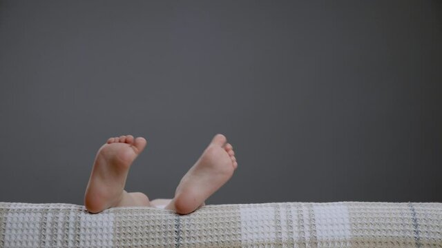 Small bare legs kids in sofa child close up toes. Kid waving funny foot comfort home girl active legs in bed time. Having fun child feet close up playfull legs kid on bed dancing. Pair of feet concept