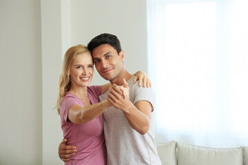 Romantic Caucasian couple. adult woman and man are enjoying dancing In the living room. wife and husband having fun anniversary enjoy care love tenderness at home