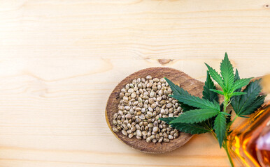 Cannabis seeds in wooden spoon on wooden table