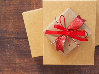 Top view, red bow tie brown gift box and  on wooden background with copy space..