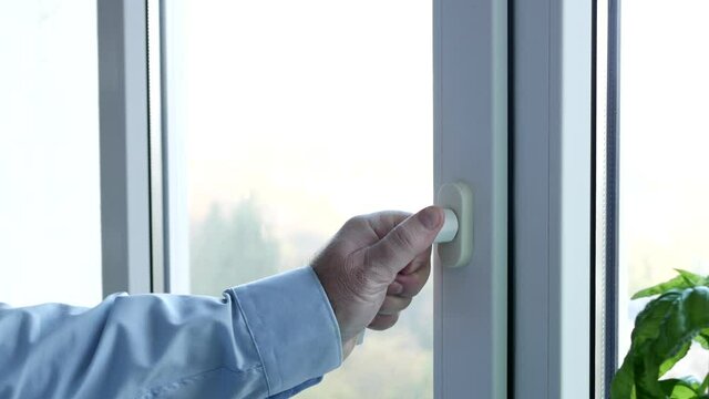 Hand of a Man Closing a Window from the Office 