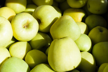 Green apples, selective focus. Street market. Ripe, juicy fruits for sale, outside on a sunny day.
