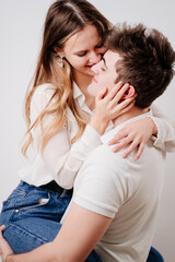 love, passionate and beautiful couple kisses, have fun against the white wall.