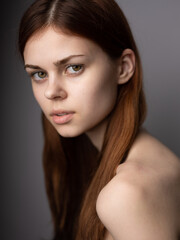 Fototapeta premium Pretty woman on gray background cropped view model red hair close up portrait