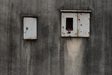 錆びた金属の箱と古びた壁
