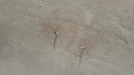 Couple playing tennis at the beach at sunset in 4K