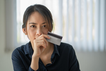 Fototapeta premium Portrait of asian woman holding credit card while looking at camera.