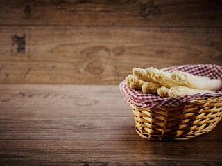 Frischer weißer Spargel im Landhaus-Korb auf einem Holztisch, Copy-Space