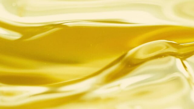 Close-up pouring golden olive oil liquid in slow motion, healthy food background